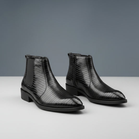 Pair of black textured leather boots on a wooden surface with a gray background