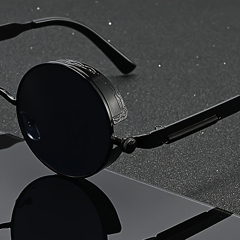 Black round-frame sunglasses with a glossy finish and textured temple arms, resting on a dark reflective surface.