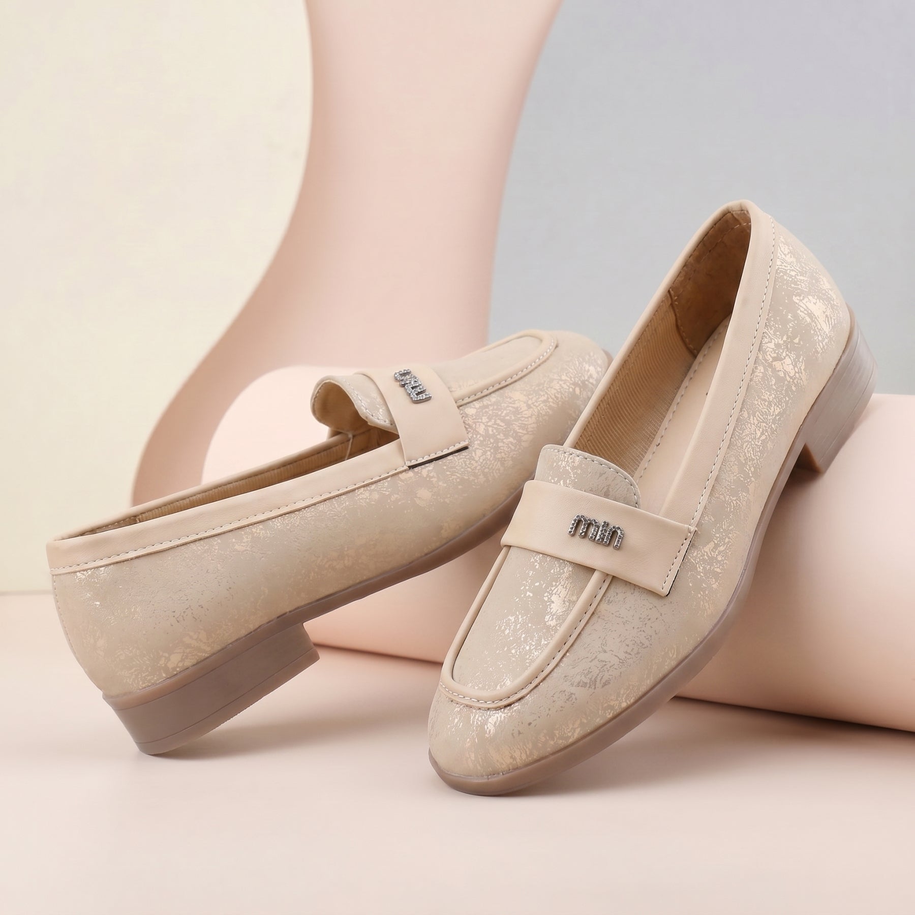 Pair of beige loafers on a light background