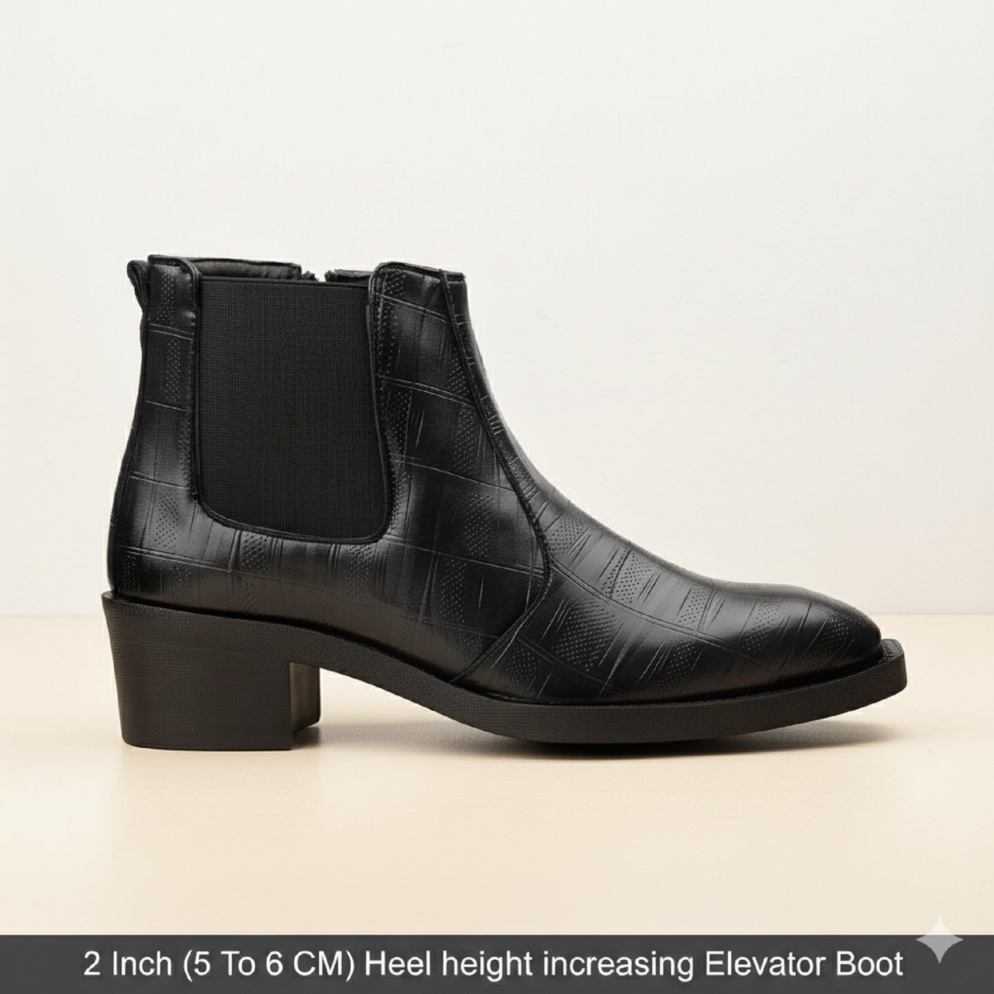 Black leather boot with a 2-inch heel on a beige background