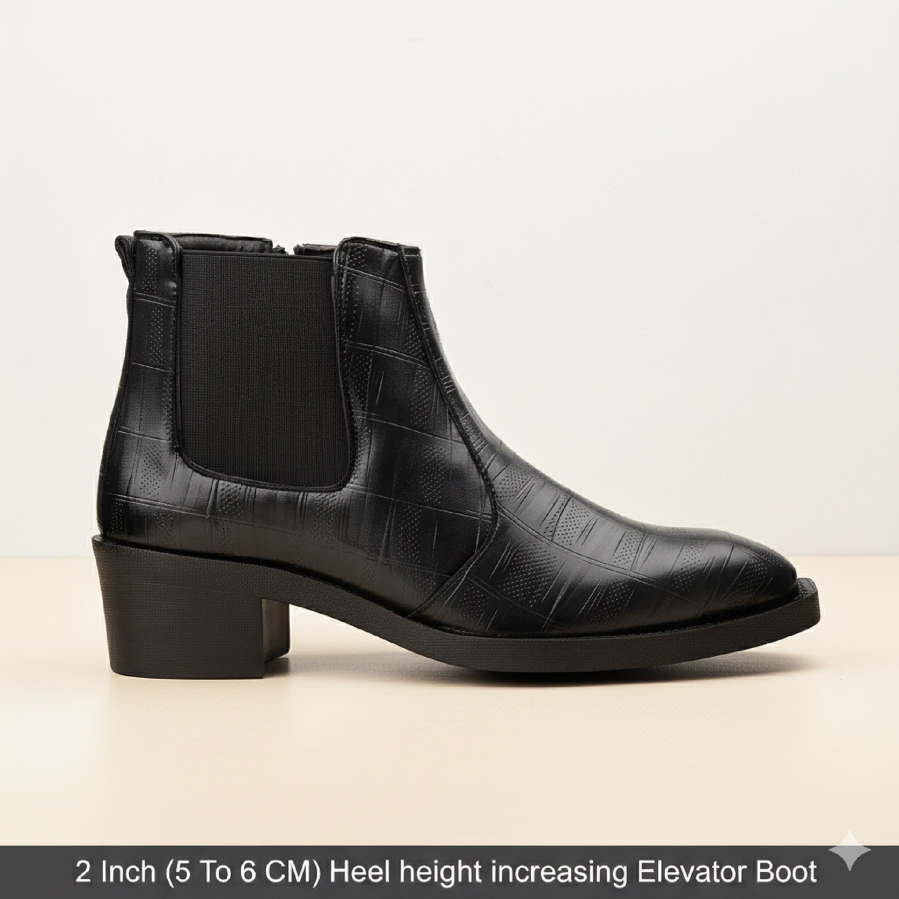 Black leather boot with a 2-inch heel on a beige background