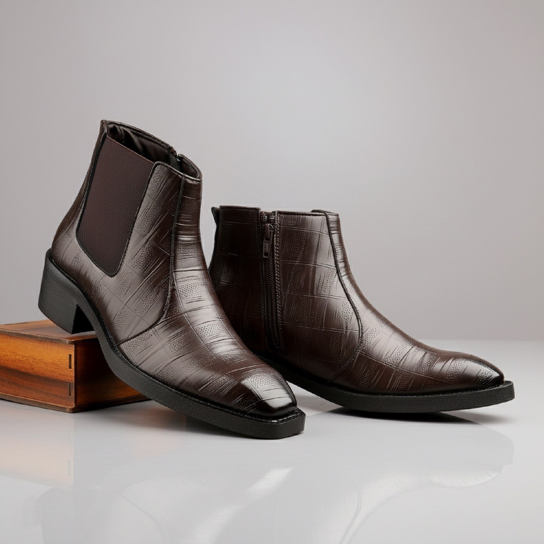 Pair of brown leather ankle boots on a light gray background