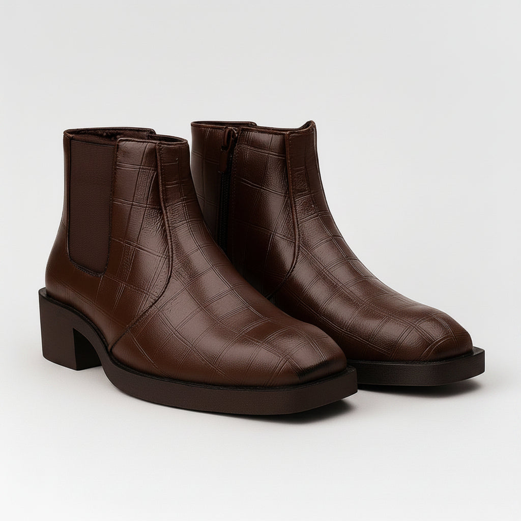 Pair of brown leather ankle boots on a light gray background