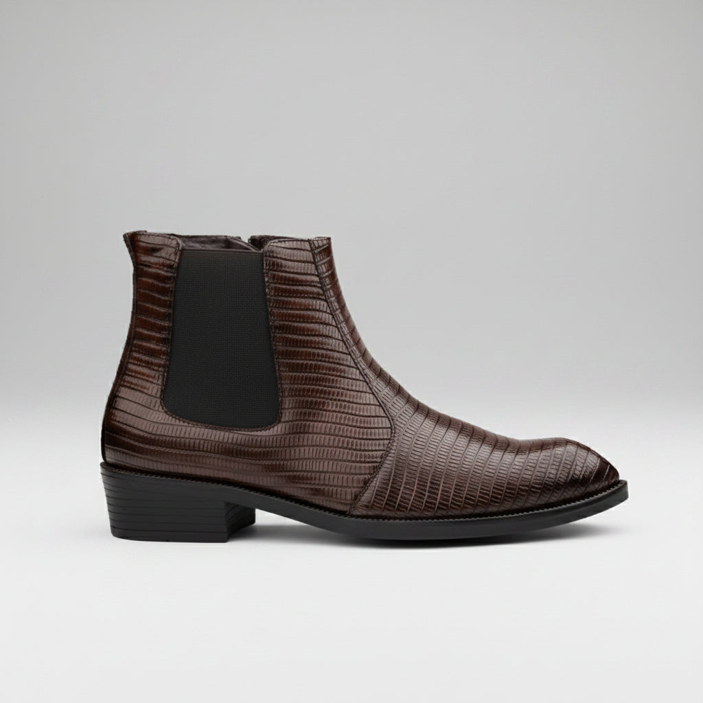 Brown Chelsea boot on a light gray floor with a blurred indoor background