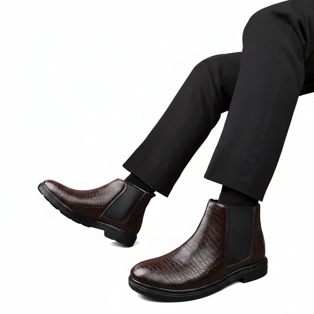 Brown leather boots worn with black pants on a beige background