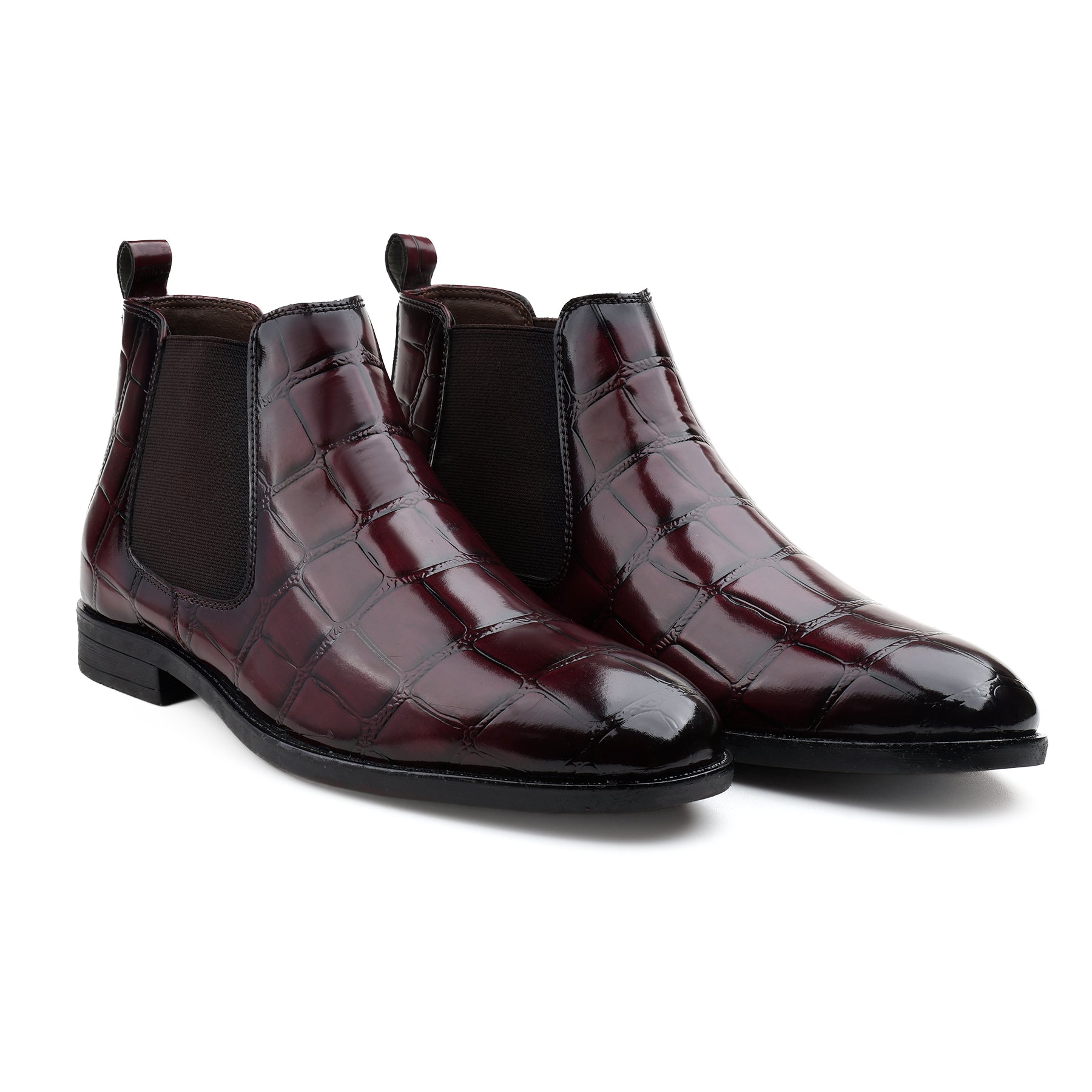 A pair of men's Chelsea boots in glossy dark burgundy crocodile-embossed leather with black elastic side panels, shown on a clean white background.
