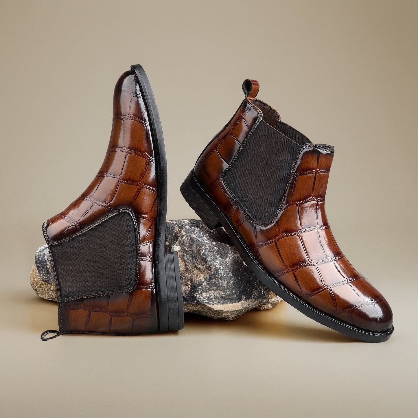 Brown leather boots with black accents on a beige background
