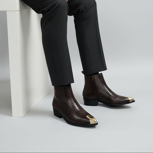 Brown ankle boots with gold toes on a light gray background