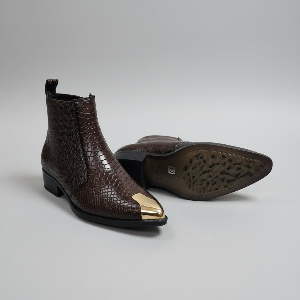 Brown ankle boots with gold toes on a light gray background