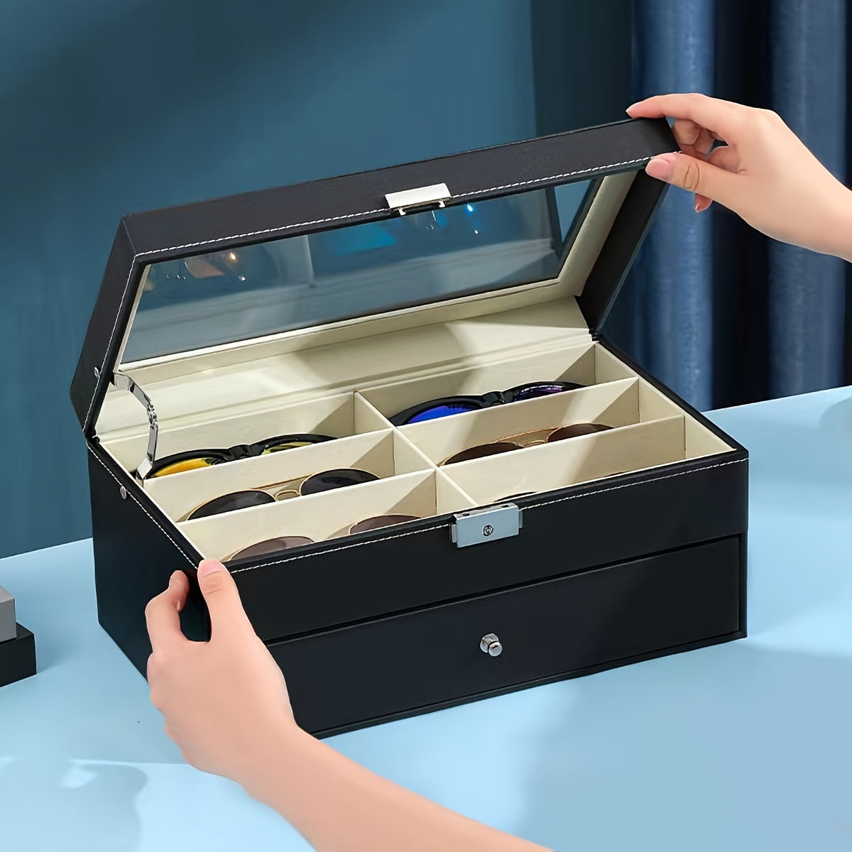 Black sunglasses case with multiple compartments on a blue surface