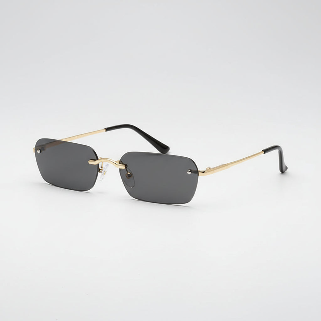 Rimless sunglasses with dark gray lenses, gold metal bridge and temples, and black temple tips, shown on a plain white background.