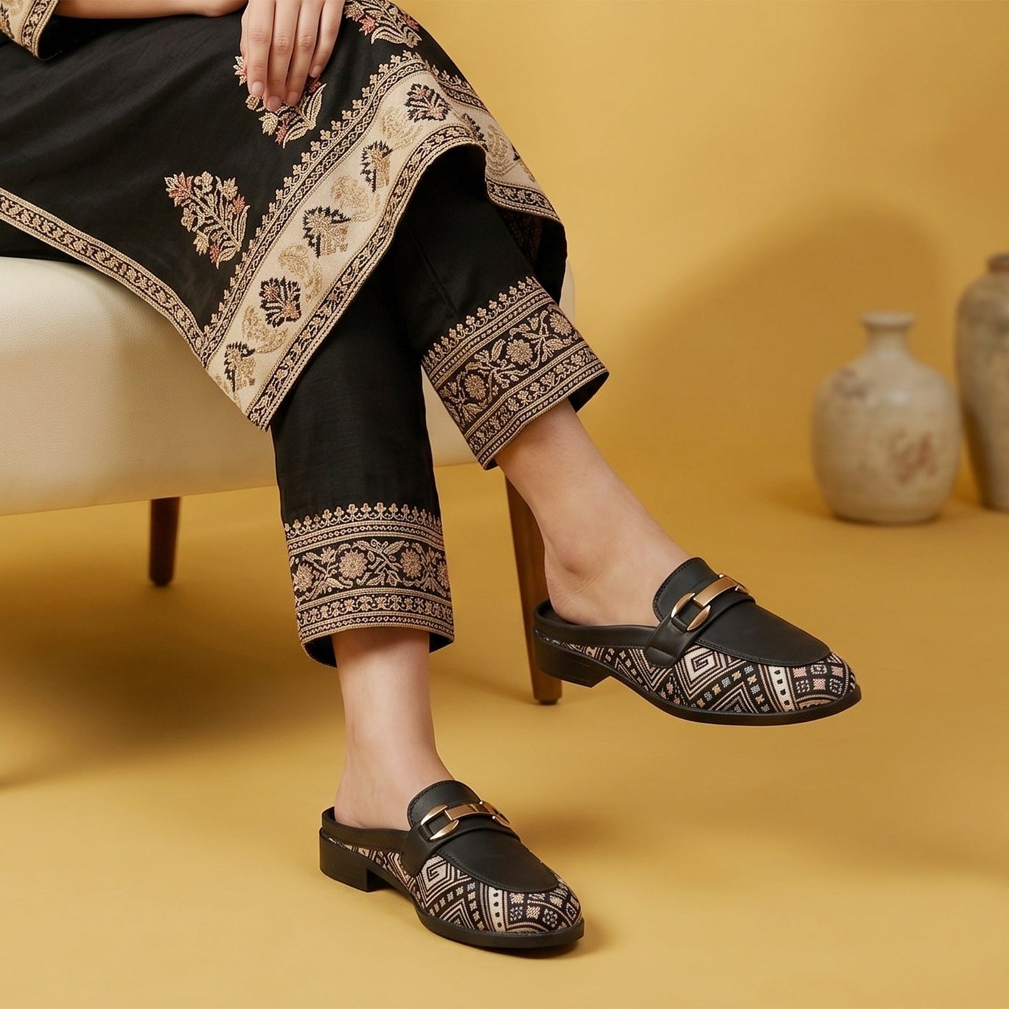 Person wearing black shoes with gold accents on a yellow background