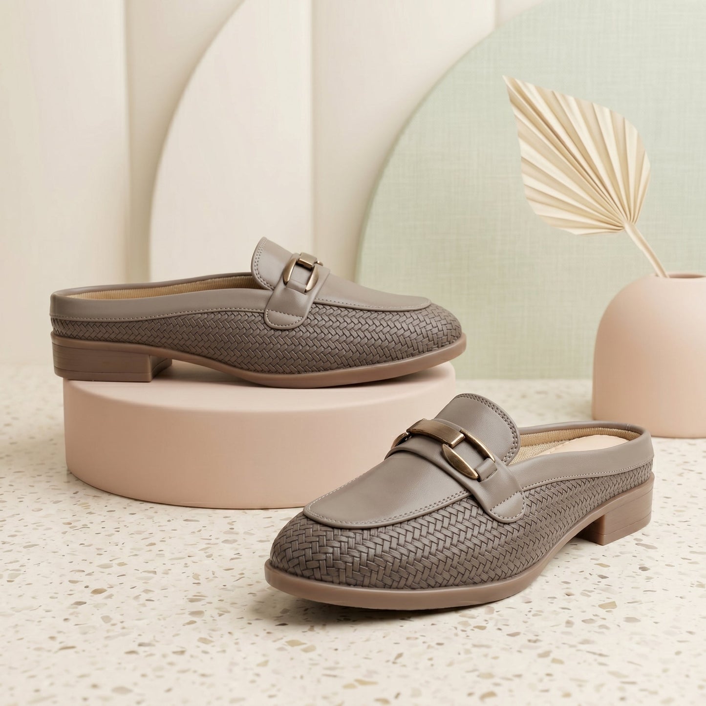 Pair of gray loafers on a textured surface with a light background