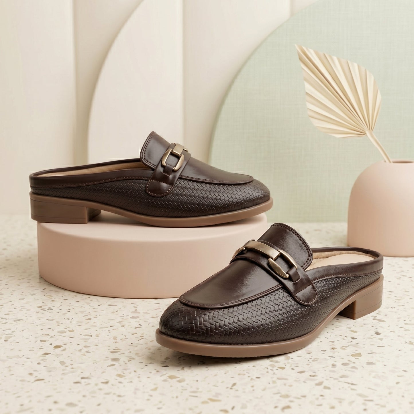 Pair of brown loafers on a textured surface with a neutral background