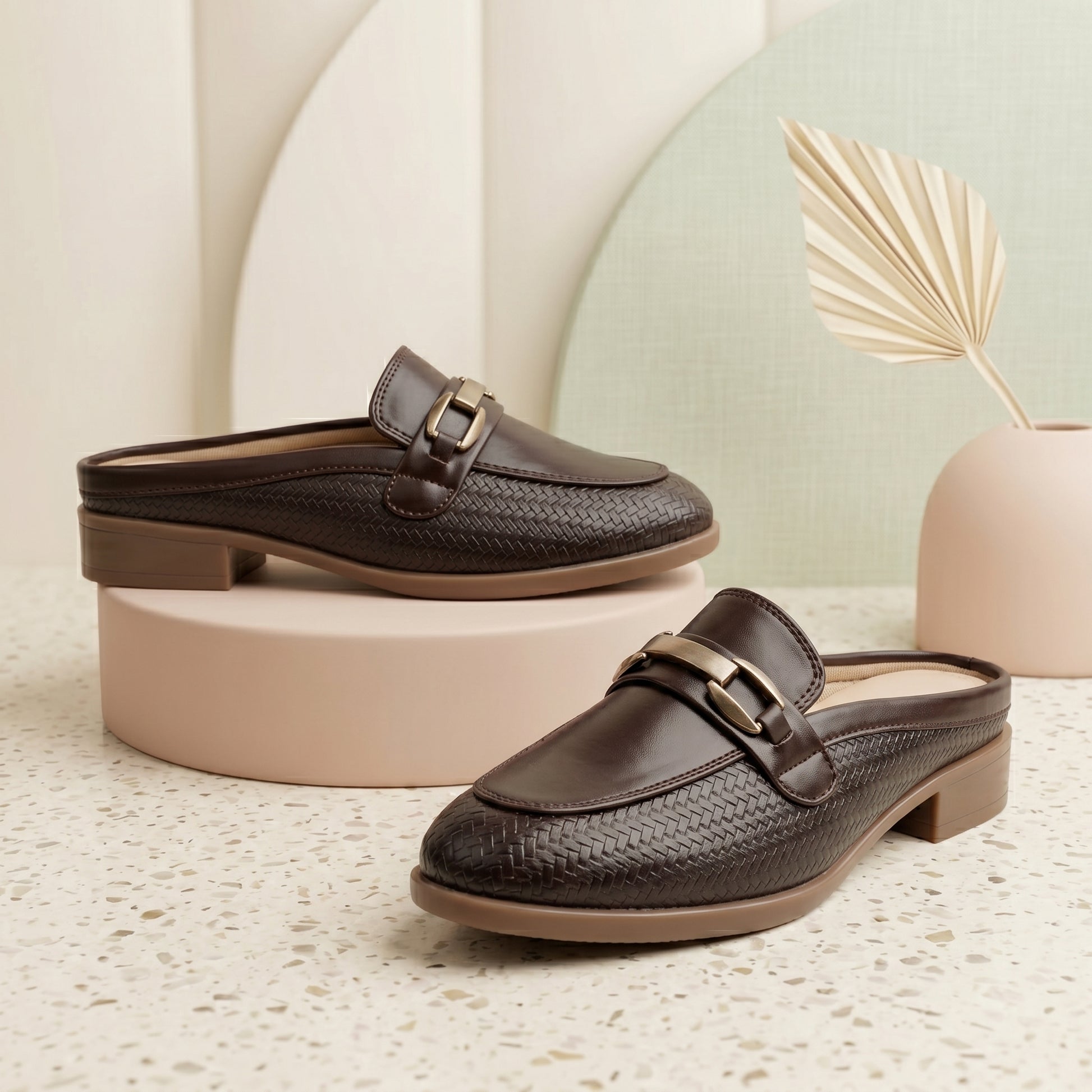 Pair of brown loafers on a textured surface with a neutral background