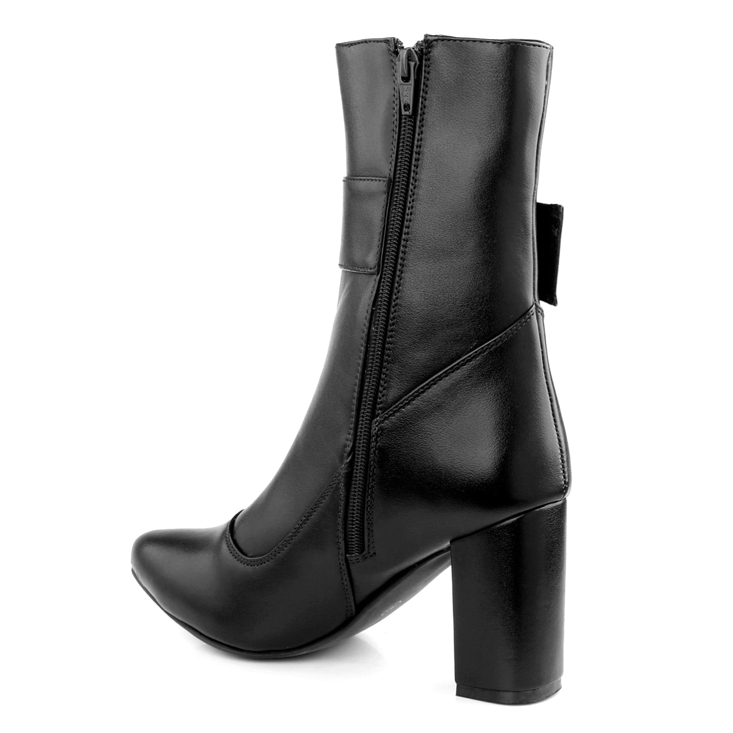 A pair of black leather ankle boots with a block heel and a silver-tone oval buckle detail on the outer side, displayed on a reddish-orange surface against a light background.