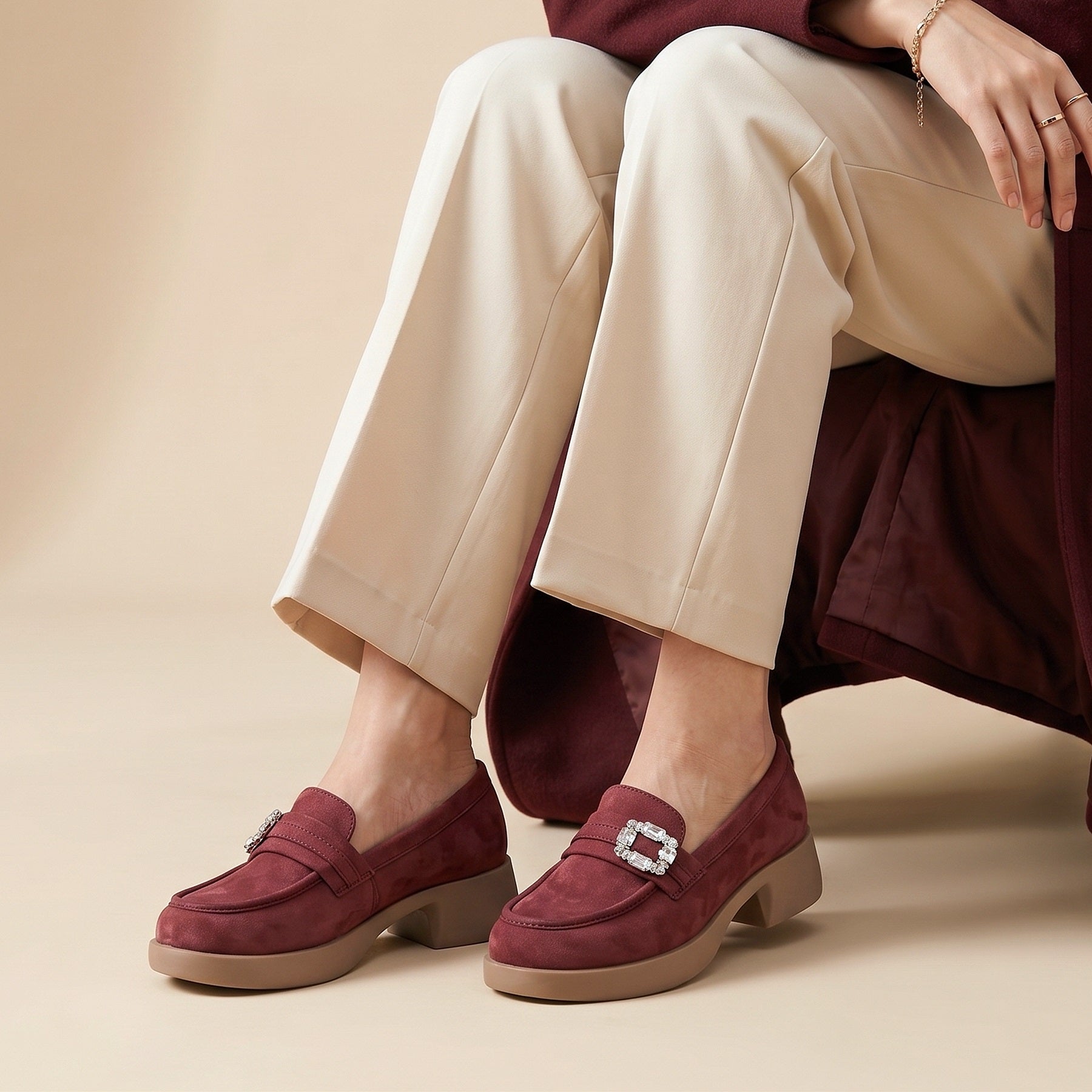Person wearing burgundy loafers with a beige background