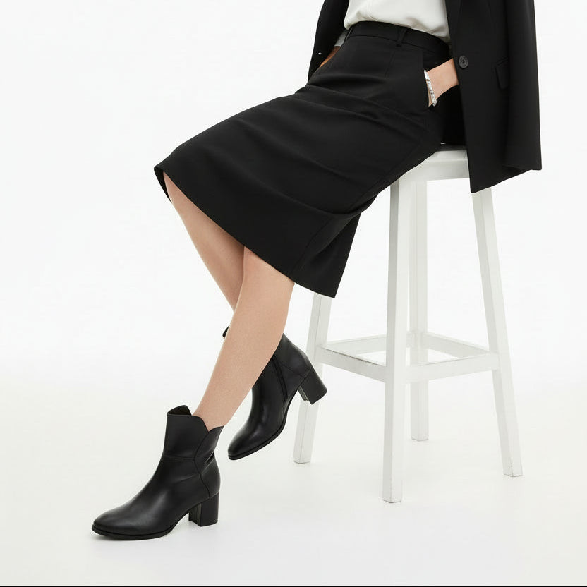 A single black leather ankle boot with a block heel and rounded toe, shown from a three-quarters angle on a white background.